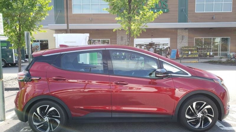 A Chevrolet Bolt in a briloiant red color is charging on a DC electric vehicle charger