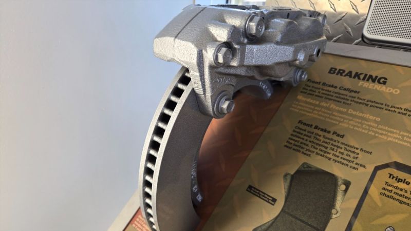 An automotive brake display explains how the rotor, caliper and brake pads work