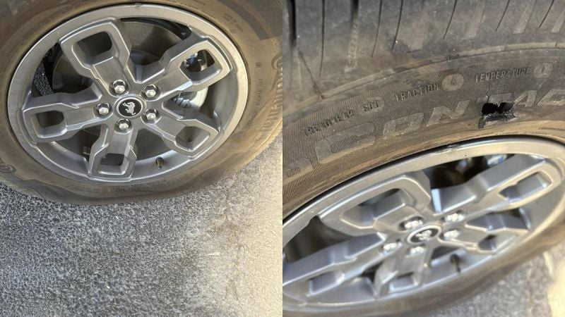 Flat tire with visible wheel rim damage and puncture, showing tire sidewall and alloy wheel details