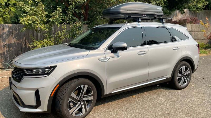 Silver Kia Sorento with cargo box mounted on roof