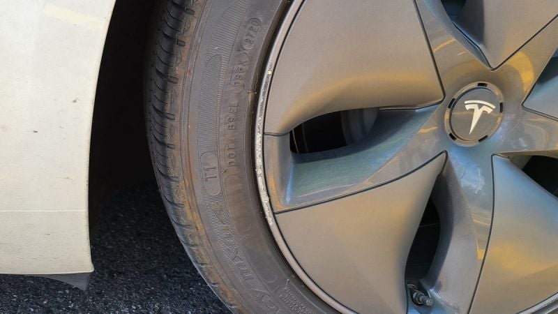 Tesla Model Y rim with scuffed paint from hitting a curb