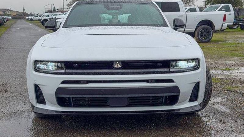 White Dodge Challenger muscle car front view in parking lot