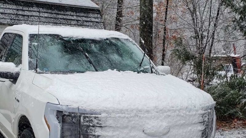 A Ford F-150 sits frozen in ice with its wipers in the up position