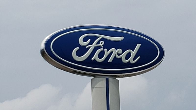 A Ford sign sits high up above a dealership