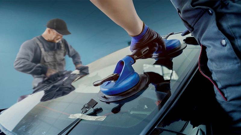 Technicians install new windshield in a Ford Product