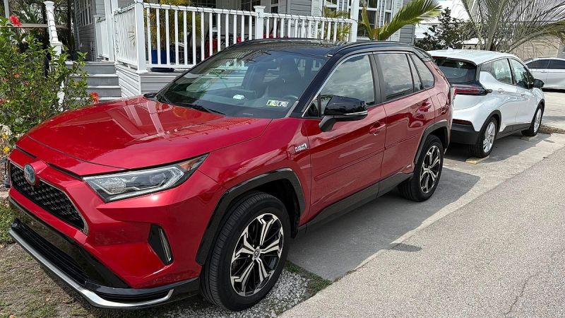 A Toyota RAV4 Prime sits in a warm Florida setting with a Chevy Bolt