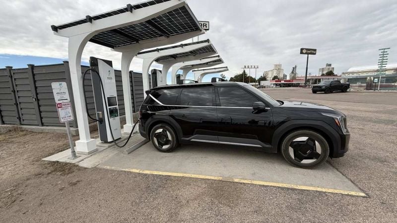 Black Kia EV6 electric vehicle charging at solar-powered charging station