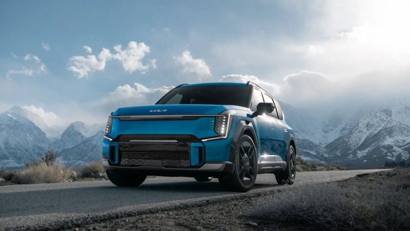 Blue Kia EV9 electric SUV parked on a scenic mountain road, showcasing rugged capability, electric SUV design, and outdoor adventure.