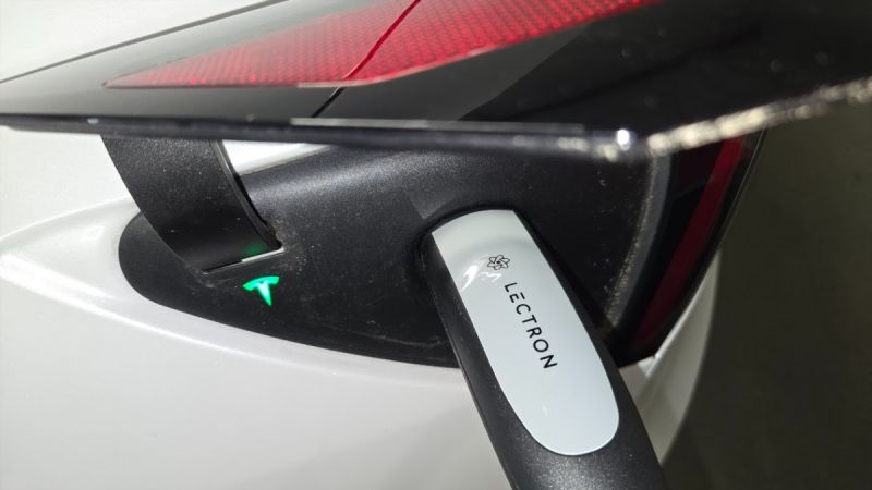 A Tesla Model Y is charged using a portable Lectron Level 2 charger during testing