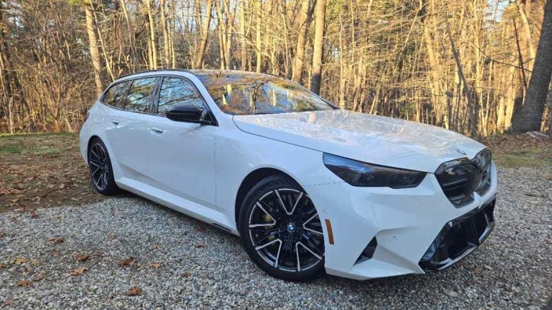 2025 BMW M5 Touring wagon set against a forest backdrop