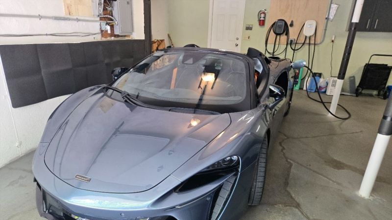 2025 McLaren Artura Spider charges on an Emporia Level 2 EV charger inside a lucky person's garage