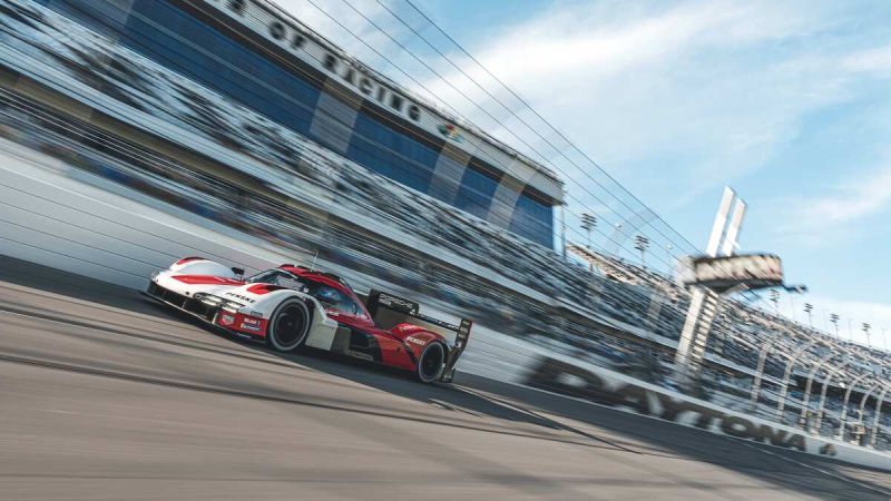 Image showing the Porsche 963 testing at Daytona as it drives at high speed on the speedway banking.