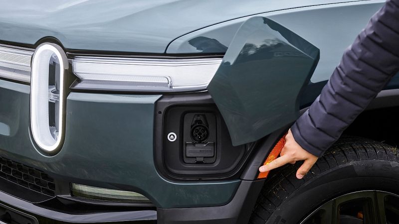 An EV drive points to the charge port of a Rivian R1S