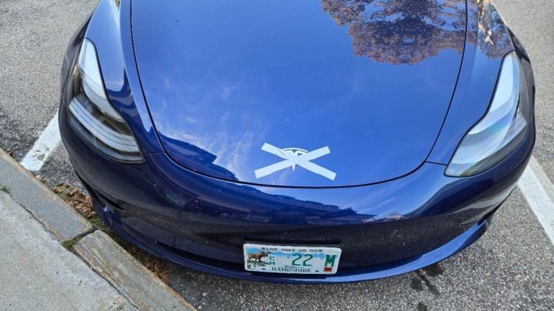 A Tesla is shown with its logo crossed out by the vehicle's owner