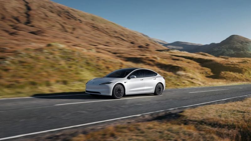 White Tesla Model 3 driving on a scenic highway through rolling hills, emphasizing electric range and minimalist design.