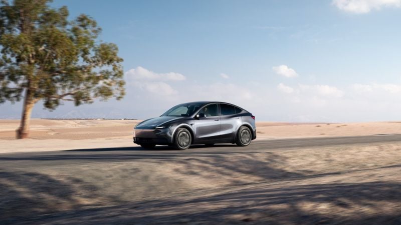 White Tesla Model Y electric crossover driving on a highway