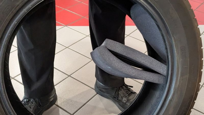 Acoustic foam falling out of a defective tire on tiled floor of a tire shop.