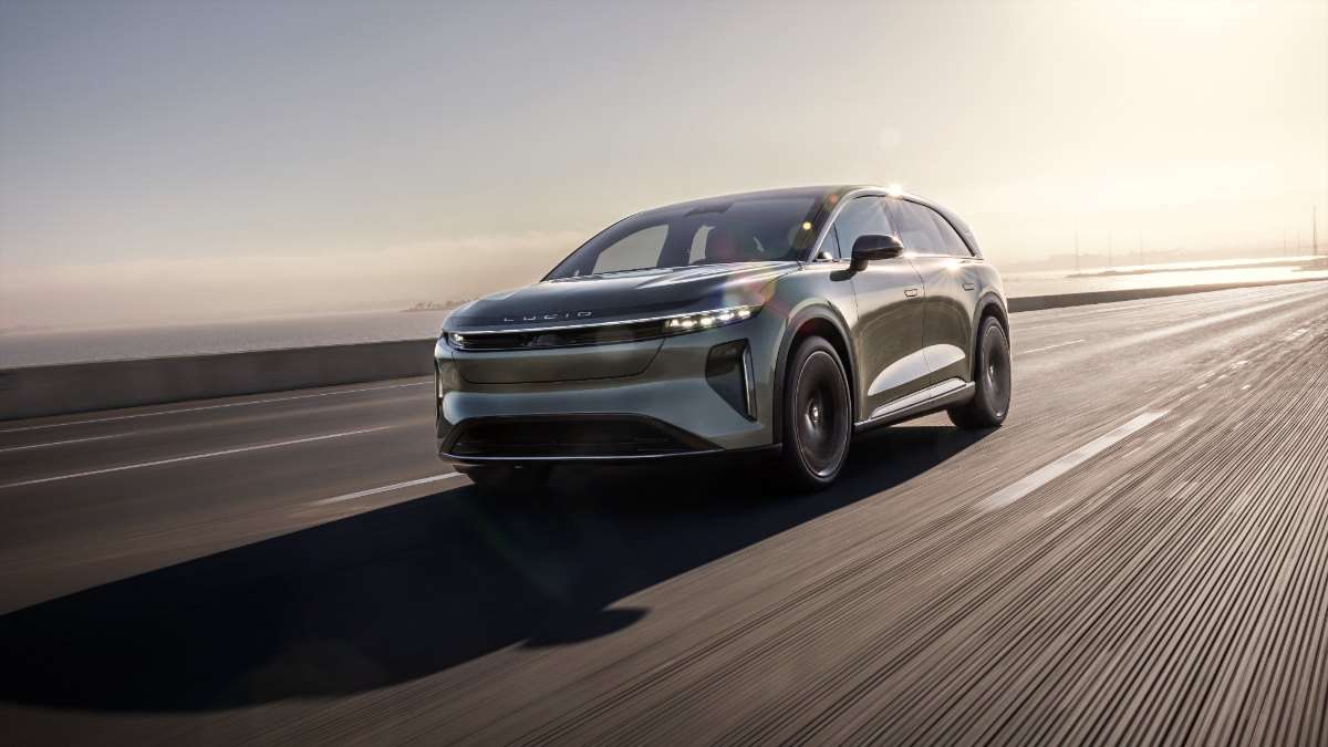 2026 Lucid Gravity electric SUV in gray, driving dynamically on highway at sunrise with sleek, aerodynamic profile