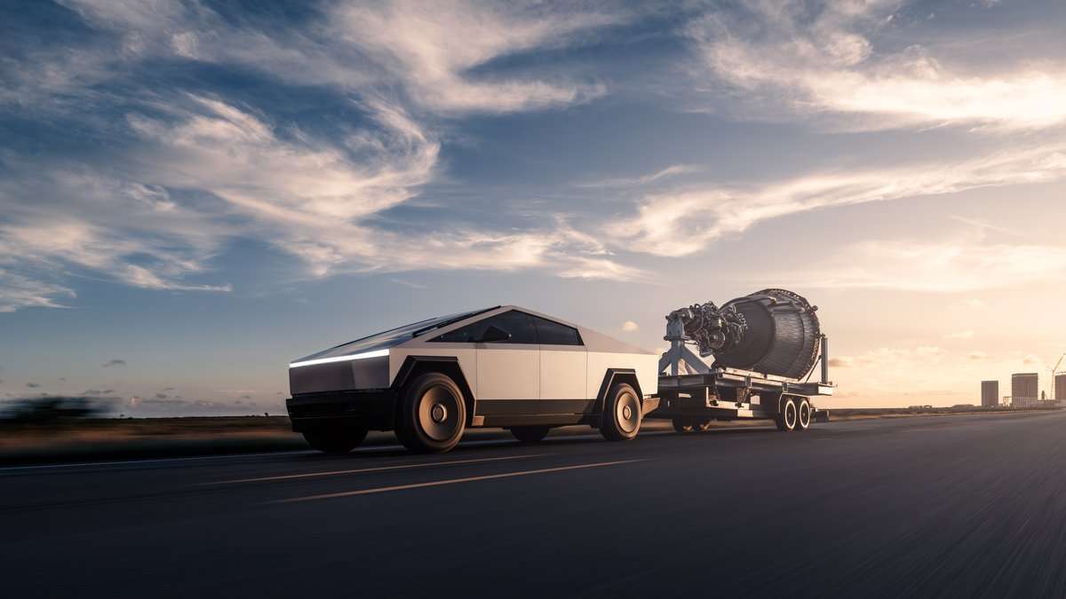 Tesla Cybertruck stainless steel electric pickup towing a large trailer on a highway at sunset