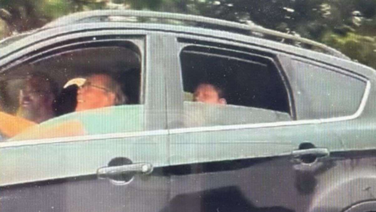 A family of three in a moving car viewed from the side. All appear to be laughing, most likely after telling Joseph what he claimed. The background shows blurred greenery.