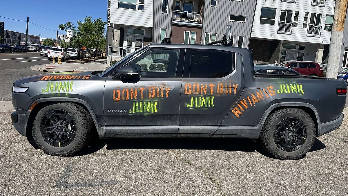 A Rivian R1T Owner Spray-Painted “Don't Buy Junk” Across His Truck and Parked It Across From Rivian's Denver Showroom After a 12-Volt Battery Dispute