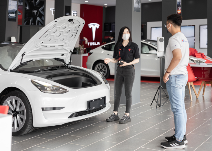  Tesla Service advisor talking to a customer about 2023 white model 3