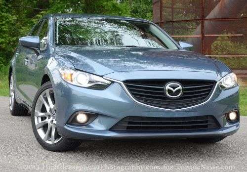 The front end of the 2014 Mazda6 Grand Touring with the headlights on