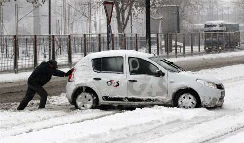 Pushing car in the snow