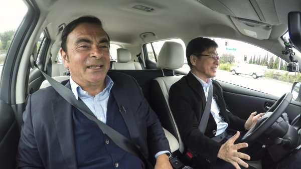 Carlos Ghosn (left) being driven in an autonomous car