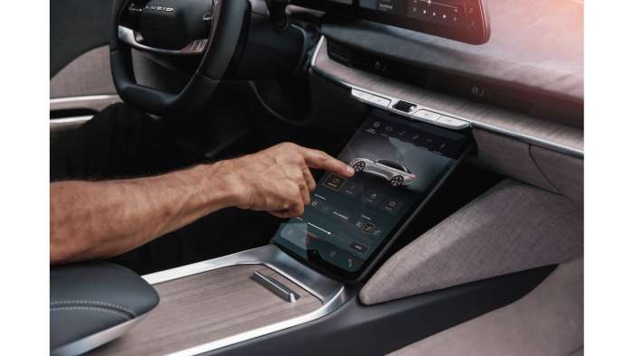 A driver operates the lower touchscreen in a Lucid Air