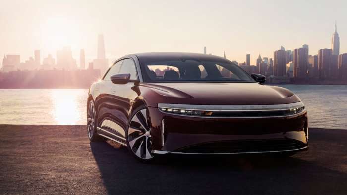 Rendering of a Lucid Air in front of a waterfront setting.