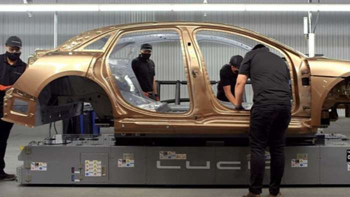 Image showing technicians assembling a Eureka gold Lucid Air at the company's AMP-1 production facility in Casa Grande, Arizona