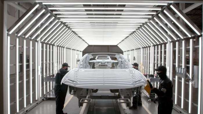 Image showing a Lucid Air passing through a well-lit inspection tunnel at the AMP-1 factory.