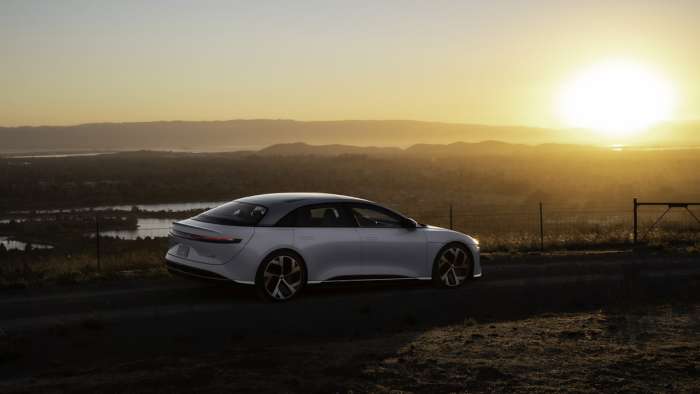 Image showing a white Lucid Air in the countryside at sunrise.