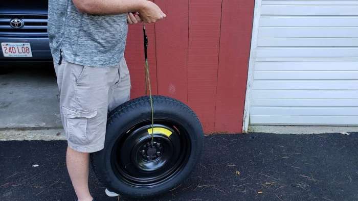 Image of John Goreham weighing a spare tire