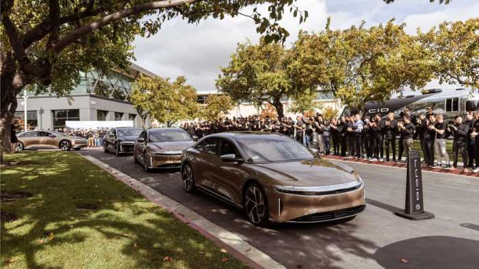 A line of Lucid Air Dream Edition sedans drive past cheering Lucid employees at the Lucid Rally 2021.