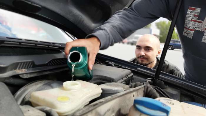 Pouring oil into a car toyota prius owner watches the mechanic