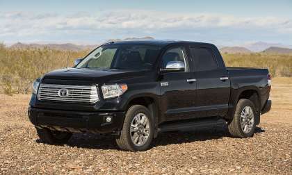 Black 2014 Toyota Tundra Platinum parked on rocky desert terrain in a front three-quarter view.