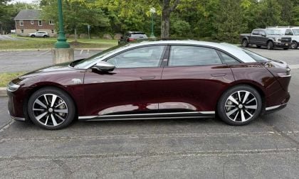 A 2022 red Lucid Air GT parked on asphalt, showcasing its modern design and distinctive alloy wheels.