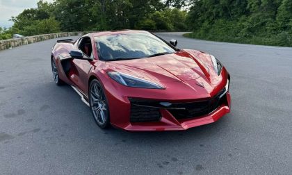 Red Chevrolet Corvette C8 parked on a scenic mountain road, front three-quarter view highlighting aggressive styling, low stance, and mid-engine sports car design.
