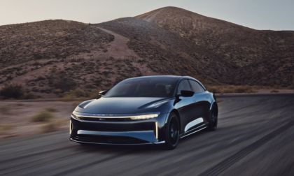 2023 Lucid Air Sapphire high-performance electric sedan in blue driving on a desert road, front three-quarter perspective.