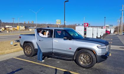 Gray 2023 Rivian R1T electric pickup shown from front three-quarter angle at a charging station.
