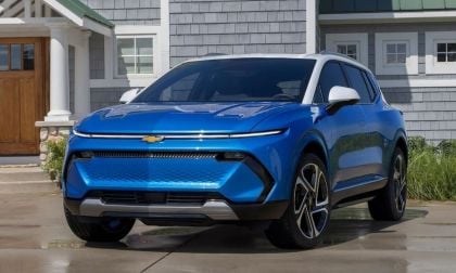 2024 Chevrolet Equinox EV blue exterior front three-quarter view parked in a residential driveway, featuring slim LED headlights and modern electric SUV styling.