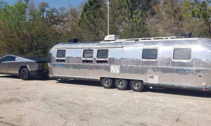 2024 Tesla Cybertruck towing a polished Airstream travel trailer, demonstrating electric truck towing capability and long-distance road travel