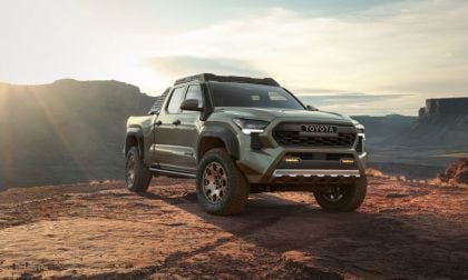 Sage green Toyota Tacoma TRD Off-Road truck parked on rocky terrain with dramatic canyon sunset backdrop