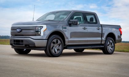 2024 Ford F-150 Lightning Flash trim in gray parked on a paved road with a grassy field and blue sky in the background.