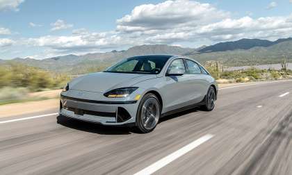 Gray 2024 Hyundai Ioniq 6 Limited driving on a desert highway with mountains in the background.