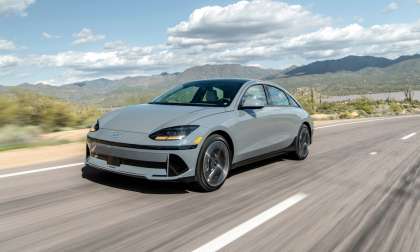 Gray 2024 Hyundai Ioniq 6 Limited driving on a desert highway with mountains in the background.