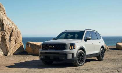 Gray 2024 Kia Telluride parked near a rocky coastal overlook with black wheels and updated Kia styling