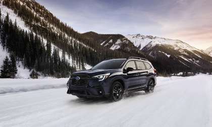 2024 Subaru Ascent driving on a snowy mountain road, shown from the front three-quarter angle.